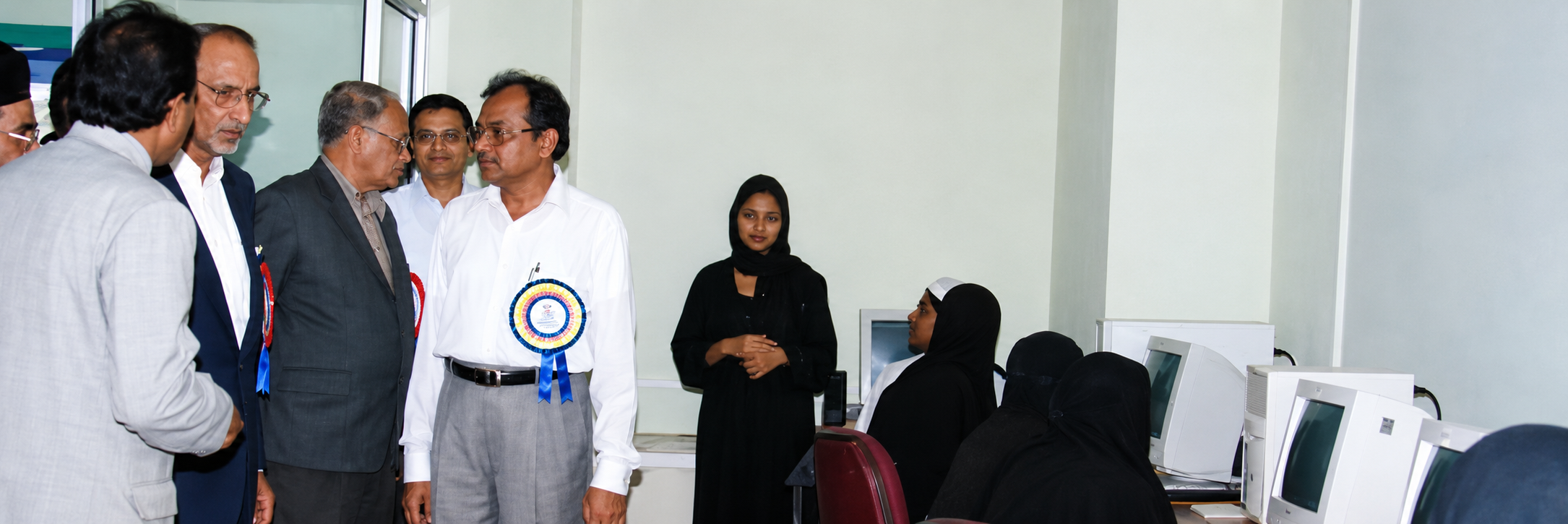 Guests visiting a computer laboratory where students are working at computers